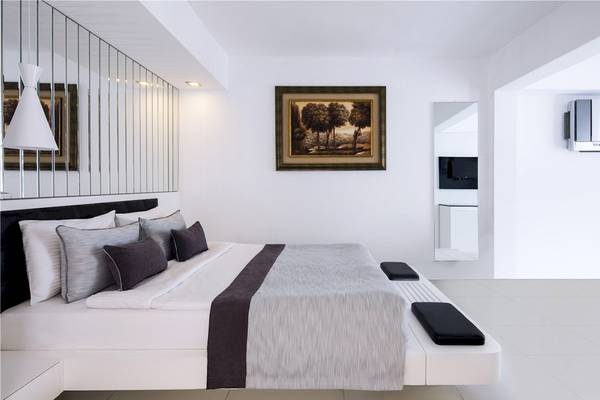 Voyage Torba Hotel Schlafzimmer mit weißem Bett, Kissen und Gemälde an der Wand.