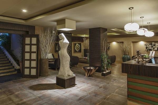 Innenansicht der Lobby des Voyage Torba Hotels mit einer Statue, Pflanzen und Möbeln.