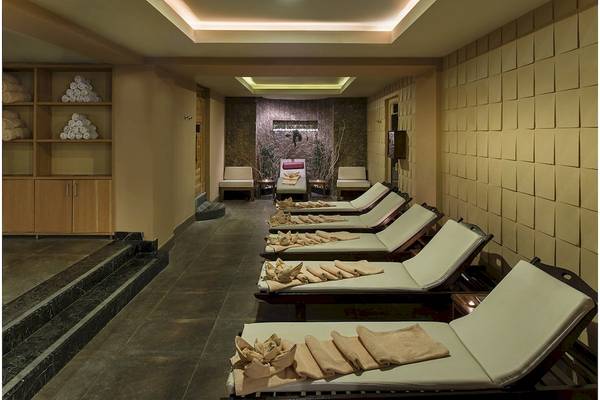 Spa-Behandlungsraum im Hotel Voyage Torba mit Liegen und Holzmöbeln.