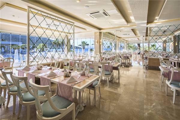 Innenansicht des Restaurants im Voyage Torba Hotel mit Blick auf den Pool und das Meer