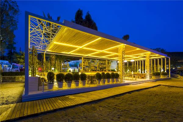 Außenbereich des Voyage Torba Hotels bei Nacht mit beleuchteter Terrasse und Pflanzenkübeln.