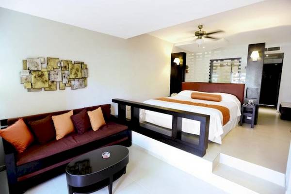 Innenansicht der Suite im Punta Cana Princess Hotel mit Bett, Sofa und Tisch.