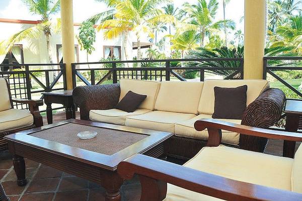 Sofa und Tisch auf dem Balkon des Punta Cana Princess Hotels mit Blick auf Palmen