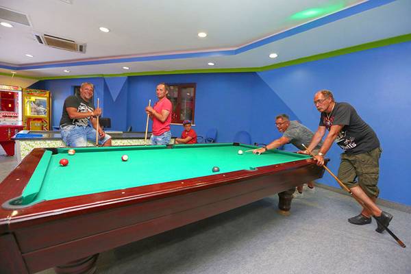 Vier Männer spielen Billard im Poolraum des Selectum Family Comfort Side Hotels.