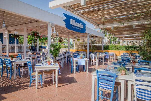 Außenbereich des Napa Plaza Hotel mit blau-weißen Tischen und Stühlen unter einem Dach.
