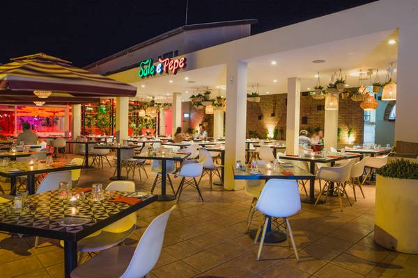 Außenbereich des Napa Plaza Hotel Restaurants bei Nacht mit beleuchteten Tischen und Stühlen.