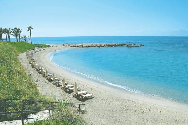 Strand des Alexander The Great Hotels mit Liegen und Palmen