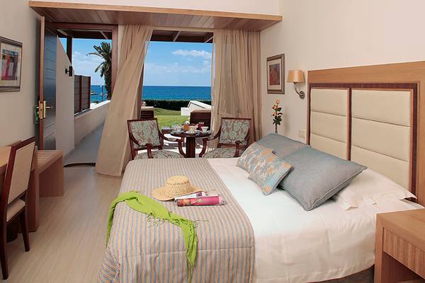 Zimmer im Alexander The Great Hotel mit Blick auf das Meer und eine Terrasse.