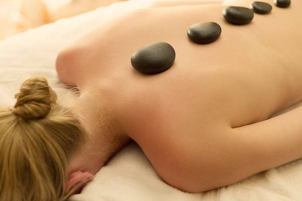 Frau mit Steinen auf dem Rücken im Hotel Massage