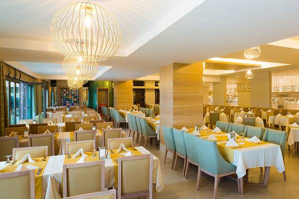 Innenansicht des Restaurants im Terrace Elite Resort mit gedeckten Tischen und Stühlen.