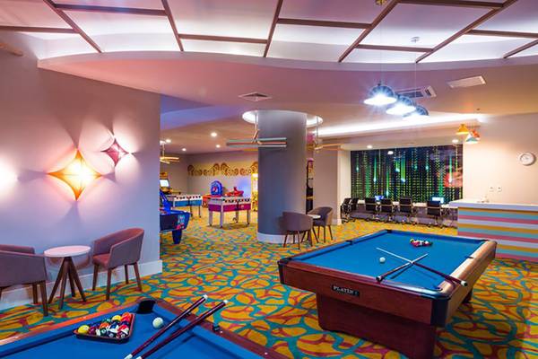 Spielzimmer im Terrace Elite Resort mit Billardtischen, Spielkonsolen und buntem Boden.