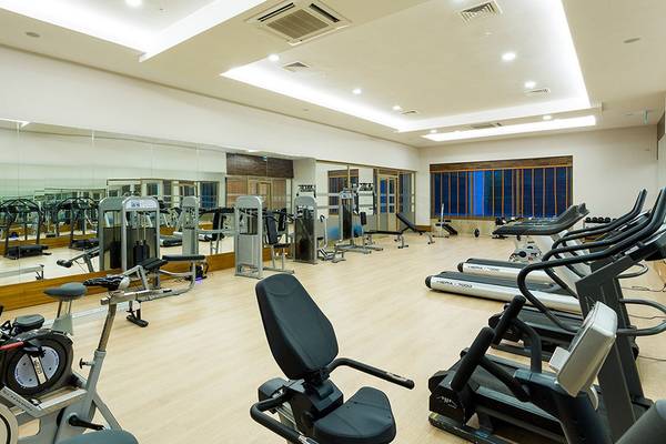 Fitnessstudio im Terrace Elite Resort mit verschiedenen Trainingsgeräten und Spiegeln.