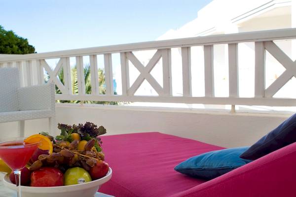 Balkon mit rotem Sofa, Obstschüssel und Cocktailglas im Radisson Blu Palace Resort & Thalasso, Djerba
