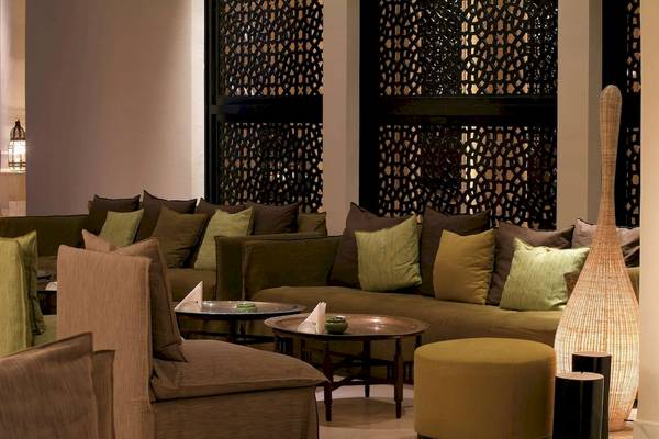 Loungebereich des Radisson Blu Palace Resort & Thalasso in Djerba mit Sofas, Tischen und einer großen Vase.