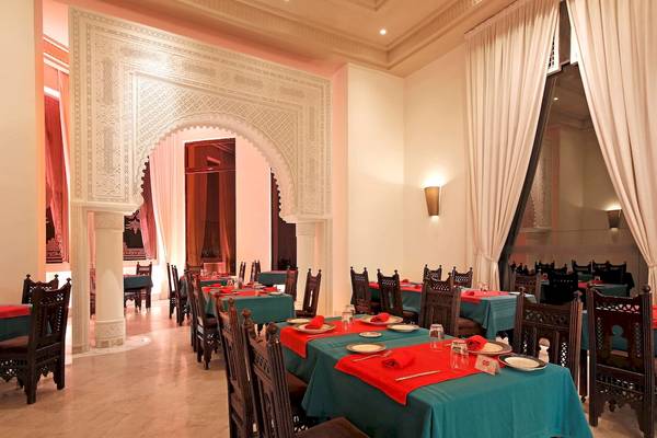 Innenansicht des Restaurants im Radisson Blu Palace Resort & Thalasso, Djerba mit blauen Tischdecken und roten Tischläufern.
