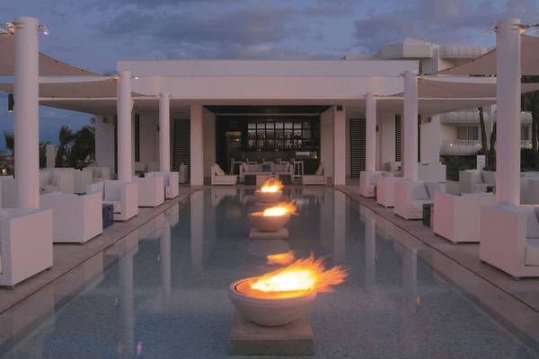 Außenbereich des Radisson Blu Palace Resort & Thalasso, Djerba mit einem Swimmingpool und weißen Möbeln.