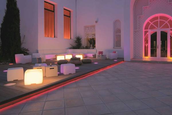 Außenbereich des Radisson Blu Palace Resort & Thalasso, Djerba, mit pinker Beleuchtung und Möbeln
