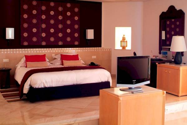Schlafzimmer im Radisson Blu Palace Resort & Thalasso, Djerba mit Bett, Fernseher und Nachttischen.