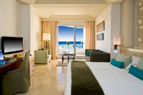 Hotelzimmer im Radisson Blu Palace Resort & Thalasso, Djerba mit Meerblick, Bett, Schreibtisch und Wohnzimmerbereich.