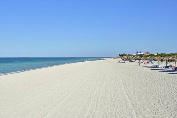 Strand des Paradisus Princesa del Mar Resort & Spa mit weißen Sand, blauem Himmel und einigen Liegestühlen