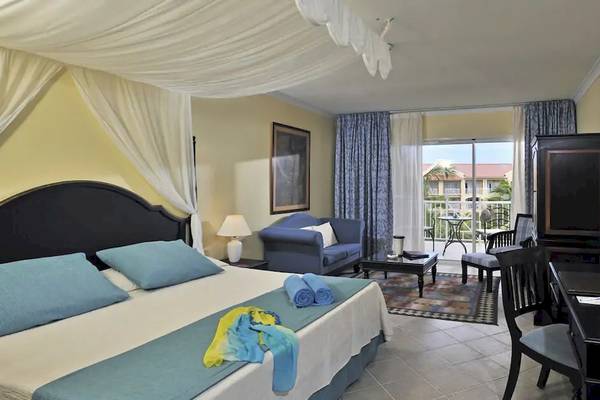 Hotelzimmer im Paradisus Princesa del Mar Resort & Spa mit Bett, Couch, Tisch, Lampen und Balkon
