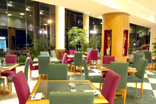 Innenansicht eines Restaurants im LABRANDA Riviera Hotel & Spa mit grün-rot karierten Sitzplätzen und Tischdekoration.