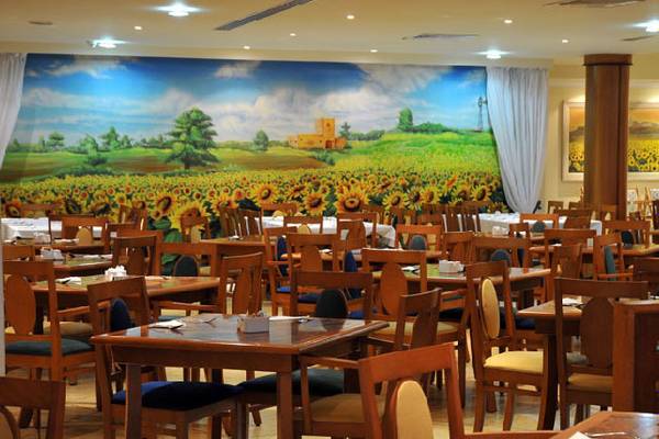 Innenansicht des Restaurants des LABRANDA Riviera Hotel & Spa mit großen Sonnenblumen-Wandbild.