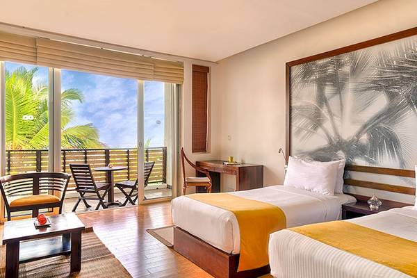 Zimmer im Jetwing Sea Hotel mit Blick auf den Balkon und das Meer.