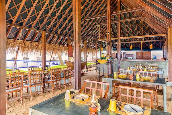 Innenansicht des Jetwing Sea Restaurants mit runden Tischen und Stühlen unter einem großen Dach.