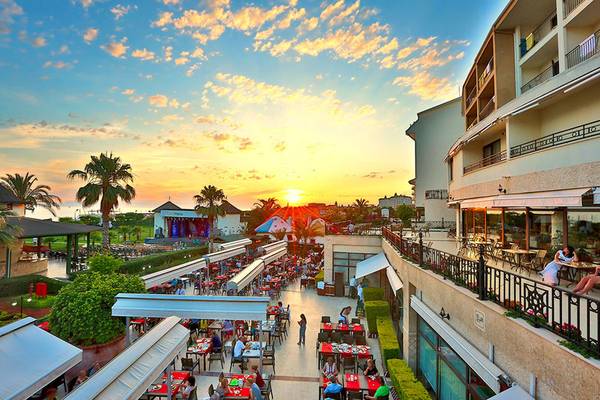 Aussicht auf das Selectum Family Comfort Side Hotel bei Sonnenuntergang mit Restaurants und Gästen
