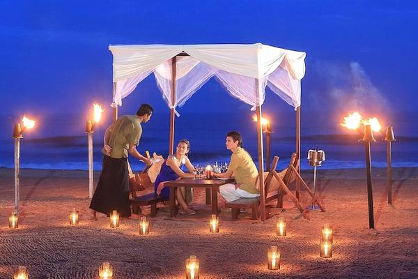 Ein Paar genießt ein romantisches Abendessen unter einem Zelt auf dem Strand des Jetwing Sea.