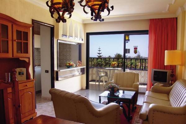 Wohnzimmer der Residenz Rey Carlos mit Balkon und Aussicht auf einen Garten.