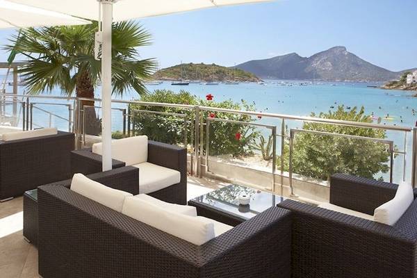 Außenbereich des Universal Hotel Aquamarin mit Blick auf das Meer und eine Palme.