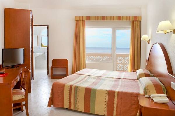 Zimmer im Universal Hotel Aquamarin mit Meerblick, inklusive Bett, Schreibtisch und Fernseher.