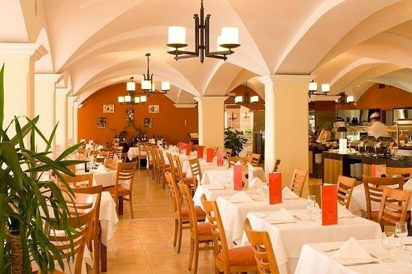 Innenbereich des Universal Hotel Aquamarin Restaurants mit gedeckten Tischen und Stühlen.