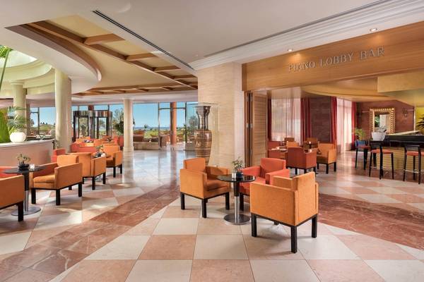 Lobby Bar des Sheraton Fuerteventura Beach, Golf & Spa Resorts mit blauen und orangefarbenen Stühlen und Tischen.