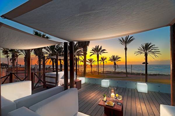 Terrasse des H10 Conquistador Hotels mit Blick auf den Sonnenuntergang und das Meer.