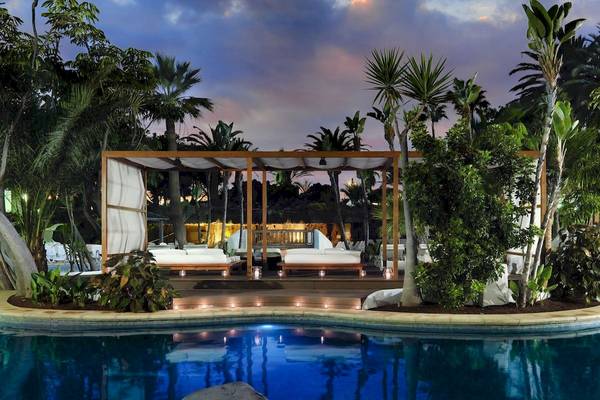 Loungebereich am Pool des H10 Conquistador Hotels mit überdachter Terrasse und beleuchteten Betten.
