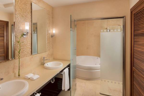 Badezimmer mit zwei Waschbecken, einer Badewanne und einer Glasdusche.