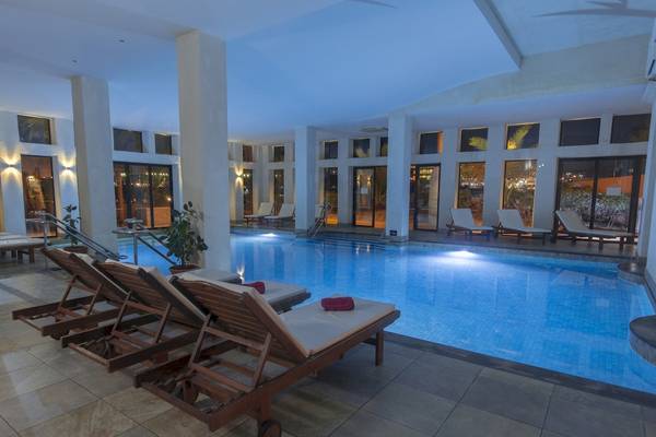 Pool-Lounge-Bereich im Ramla Bay Resort mit Liegestühlen und Swimmingpool