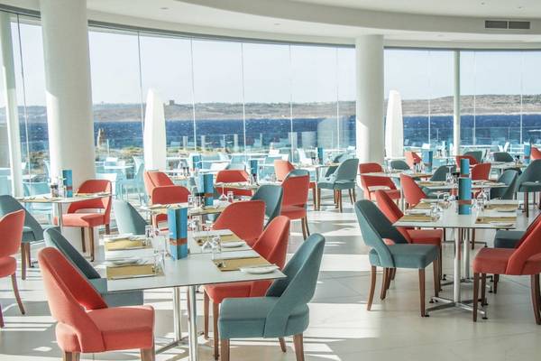 Innenansicht des Restaurants im Ramla Bay Resort mit Blick auf das Meer.