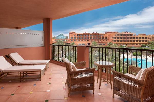 Balkon des Sheraton Fuerteventura Beach, Golf & Spa Resort mit Sonnenliegen und Sessel.