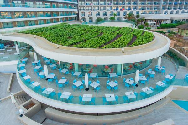 Luftaufnahme des Ramla Bay Resorts mit grünem Dach und runden Außenbereich für Gäste.