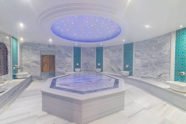 Wellnessbereich im Ramla Bay Resort mit einem großen Whirlpool und Marmorwänden.