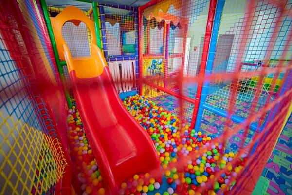 Kinderspielplatz im Ramla Bay Resort mit einer roten Rutsche und bunten Bällen.