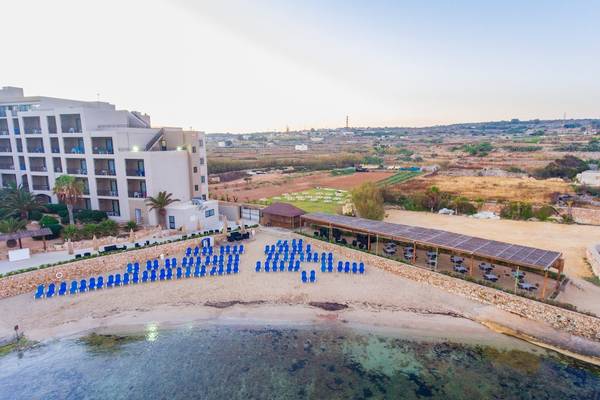 Luftaufnahme des Ramla Bay Resorts mit Hotel, Strand und Sonnenliegen