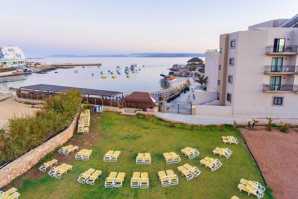 Luftaufnahme des Ramla Bay Resorts mit Blick auf das Meer und Sonnenliegen.
