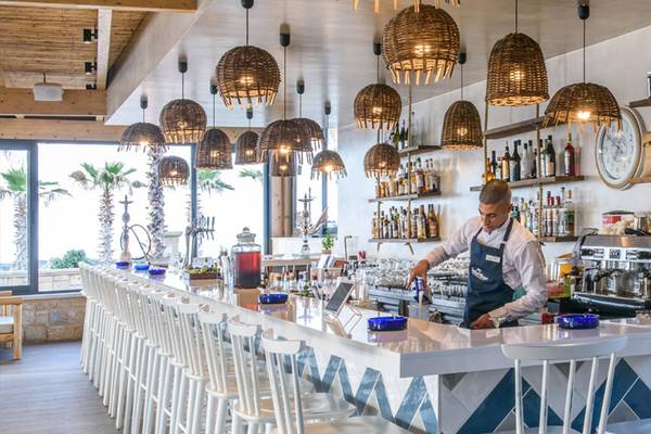 Ein Barkeeper serviert Getränke in der Bar des Stella Palace Resort & Spa.