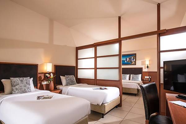 Doppelzimmer im Stella Palace Resort & Spa mit zwei Betten, Fernseher und Schreibtisch.