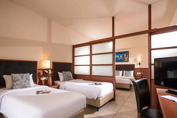 Doppelzimmer im Stella Palace Resort & Spa mit zwei Betten, Schreibtisch und Fernseher.